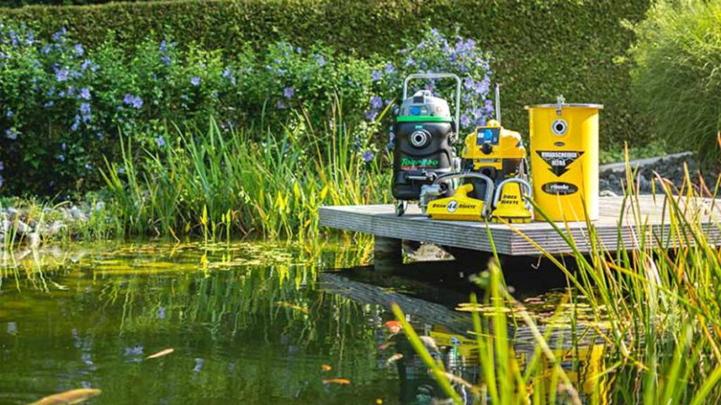 Sortiment von Teichpflege Produkten auf einem Holzsteg bei einem schönen Teich