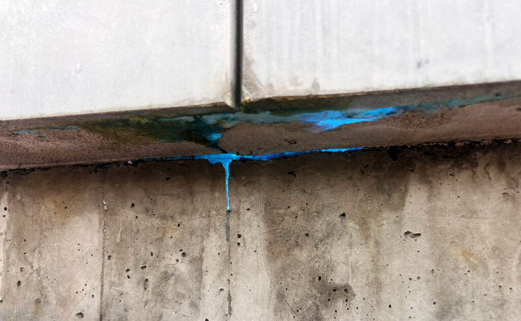 Un traceur UV bleu s'échappe d'un mur en béton