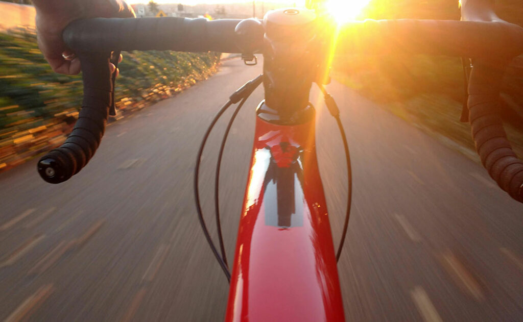 Velofahrer im Gegenlicht bei Sonnenuntergang