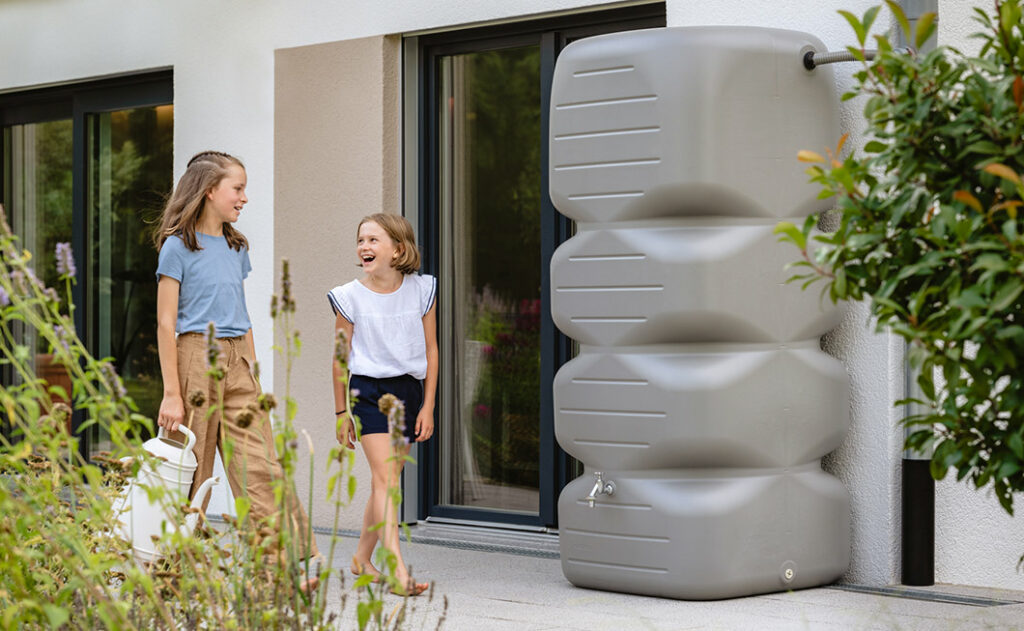 Regenspeicher Cubus im Garten mit zwei Kindern