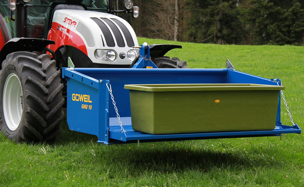 Traktor mit Brunnen auf der Schaufel