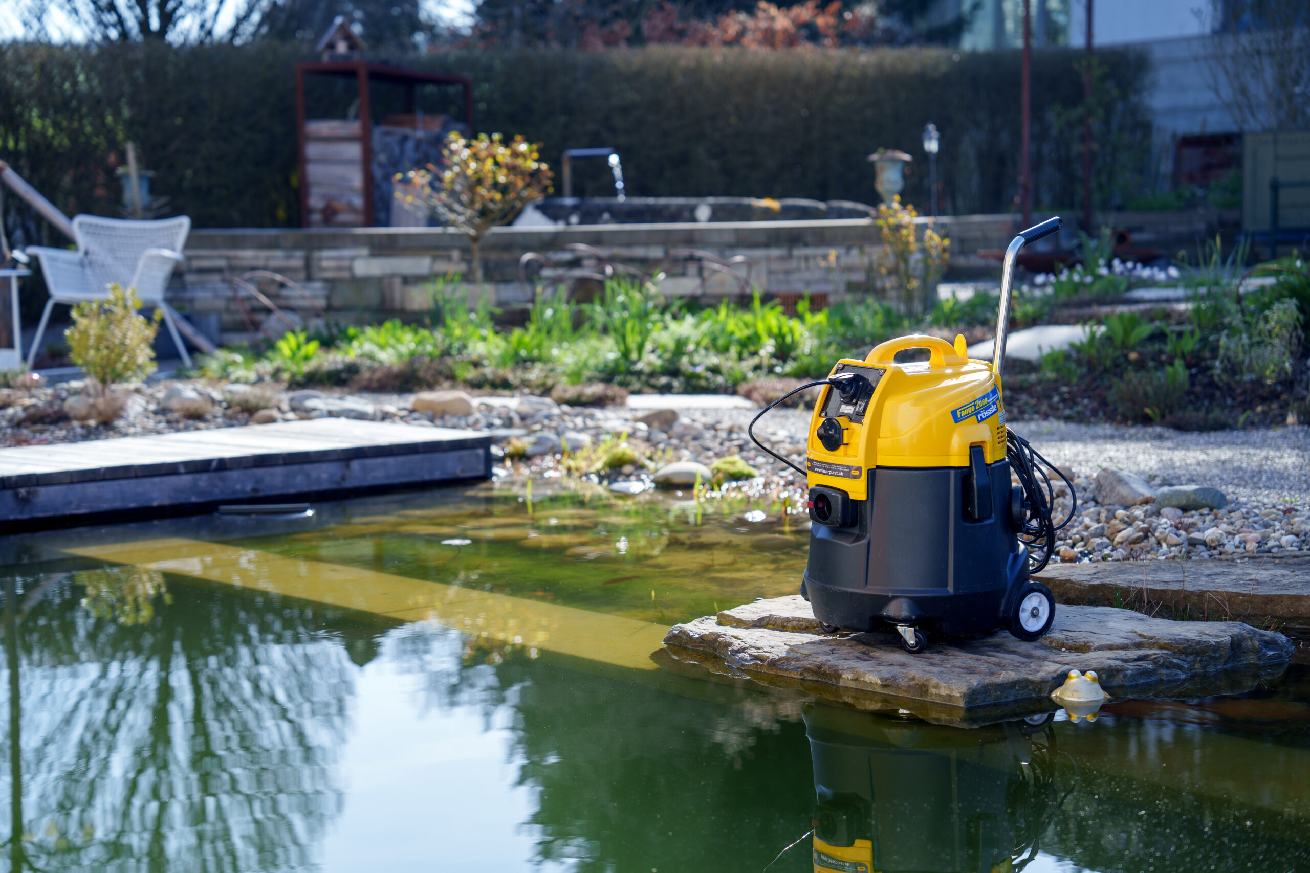 Teichschlammsauger Fango 2000 vor einem Gartenteich
